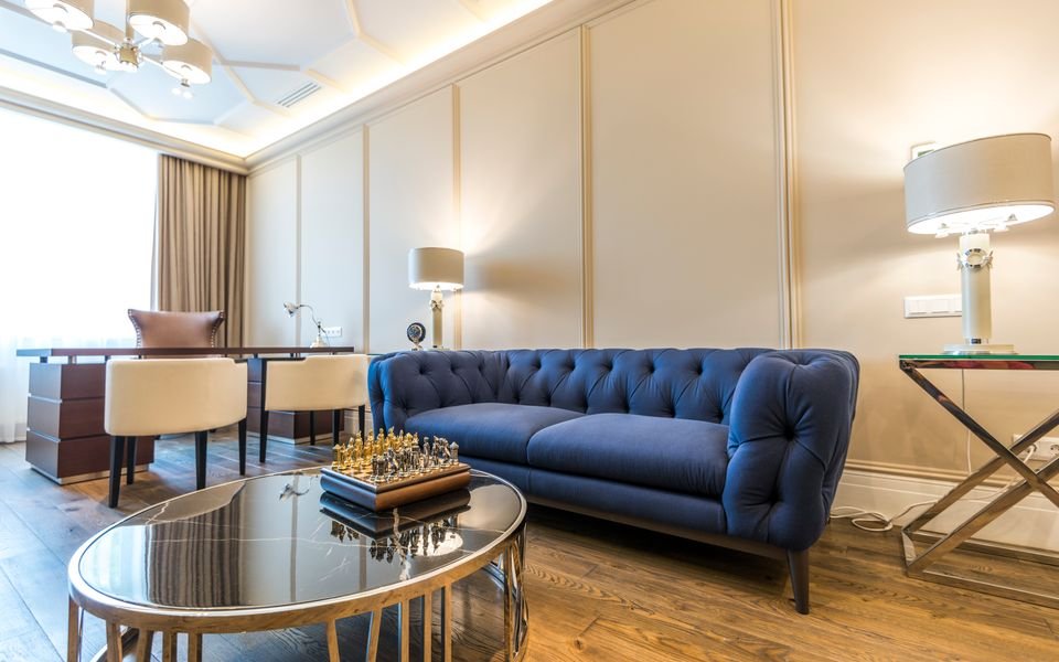 Living room with cream panelled walls and a navy sofa