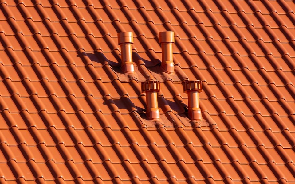 Restored terracotta roof tiles around four roof vents