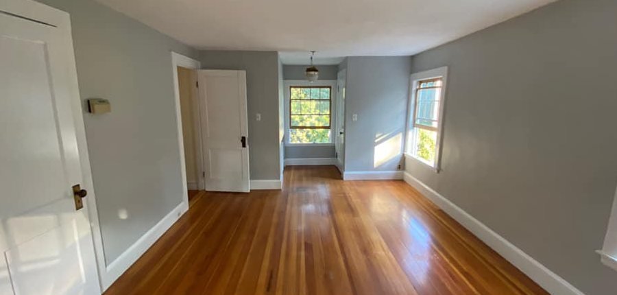 A finished room: pale grey walls, white trims and a polished timber floor