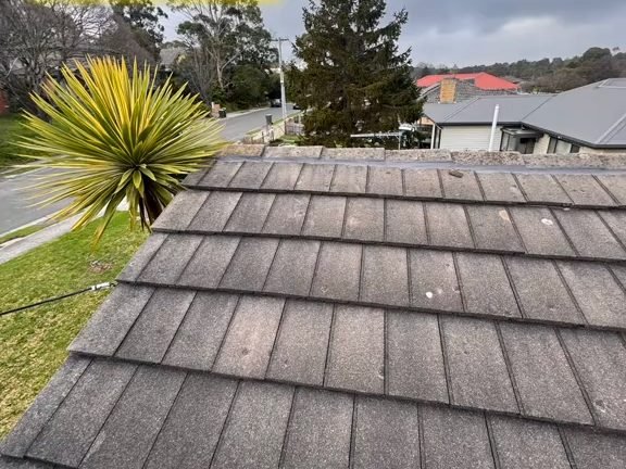 A weathered concrete tile roof before restoration