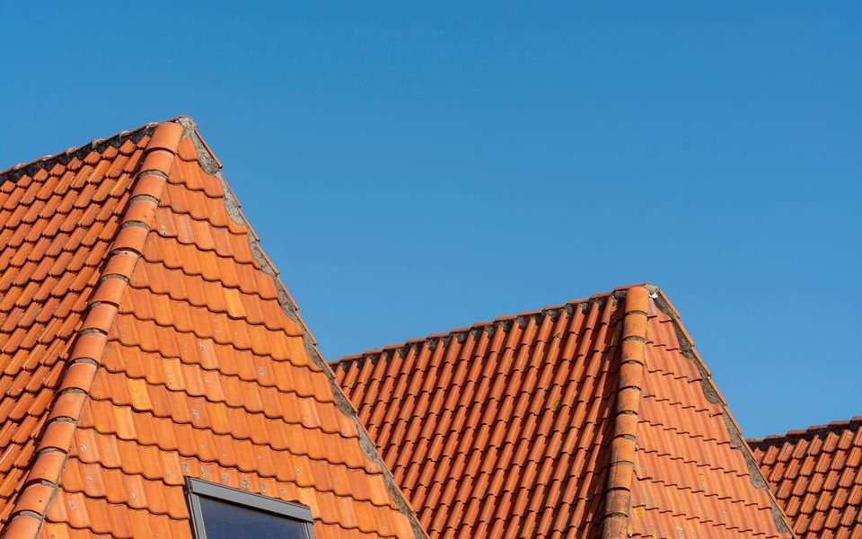 Terracotta tiled gables against a clear blue sky