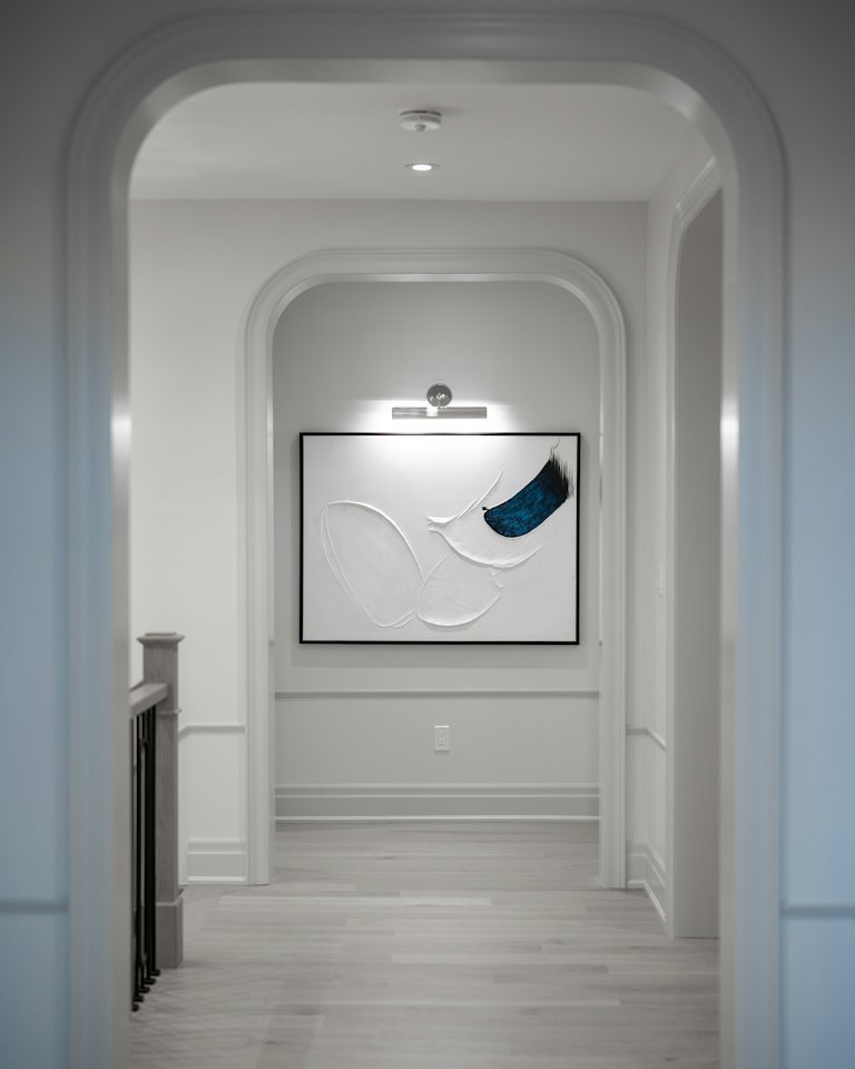 White hallway with an arched niche and crisp painted trims