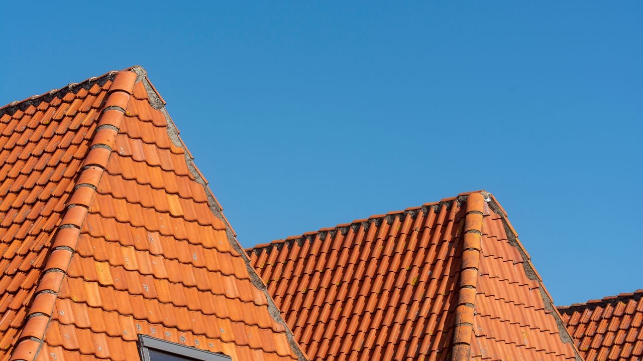 Terracotta tiled gables against a clear blue sky